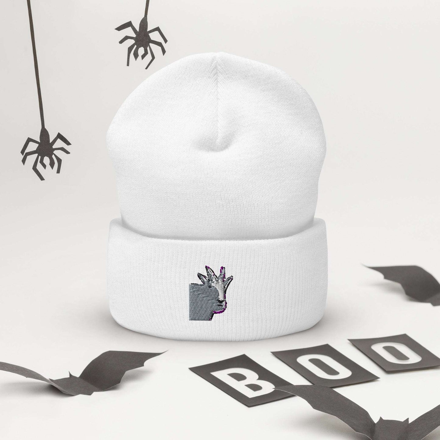 A high-quality white unisex cuffed beanie that has an embroidery of a funny mountain goat design.