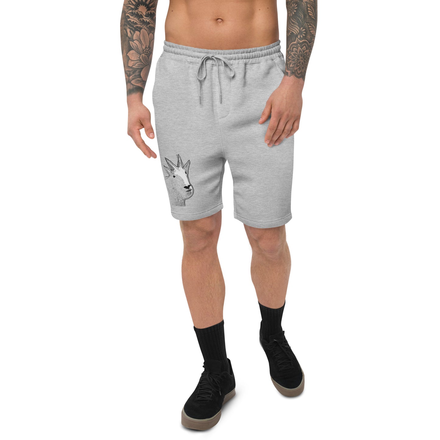 A male model with arm tattoos wearing a pair of grey fleece shorts with a funny mountain goat design on the right leg and a pair of black shoes.