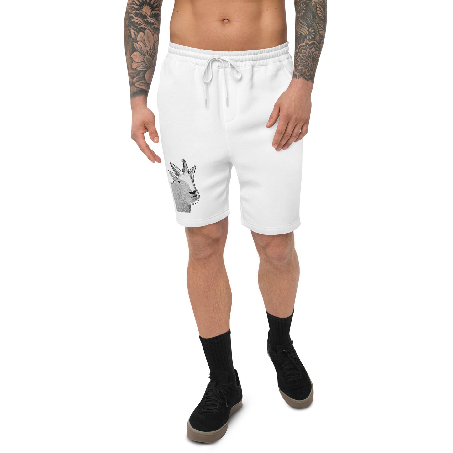 A male model with arm tattoos wearing a pair of white fleece shorts with a funny mountain goat design on the right leg and a pair of black shoes.