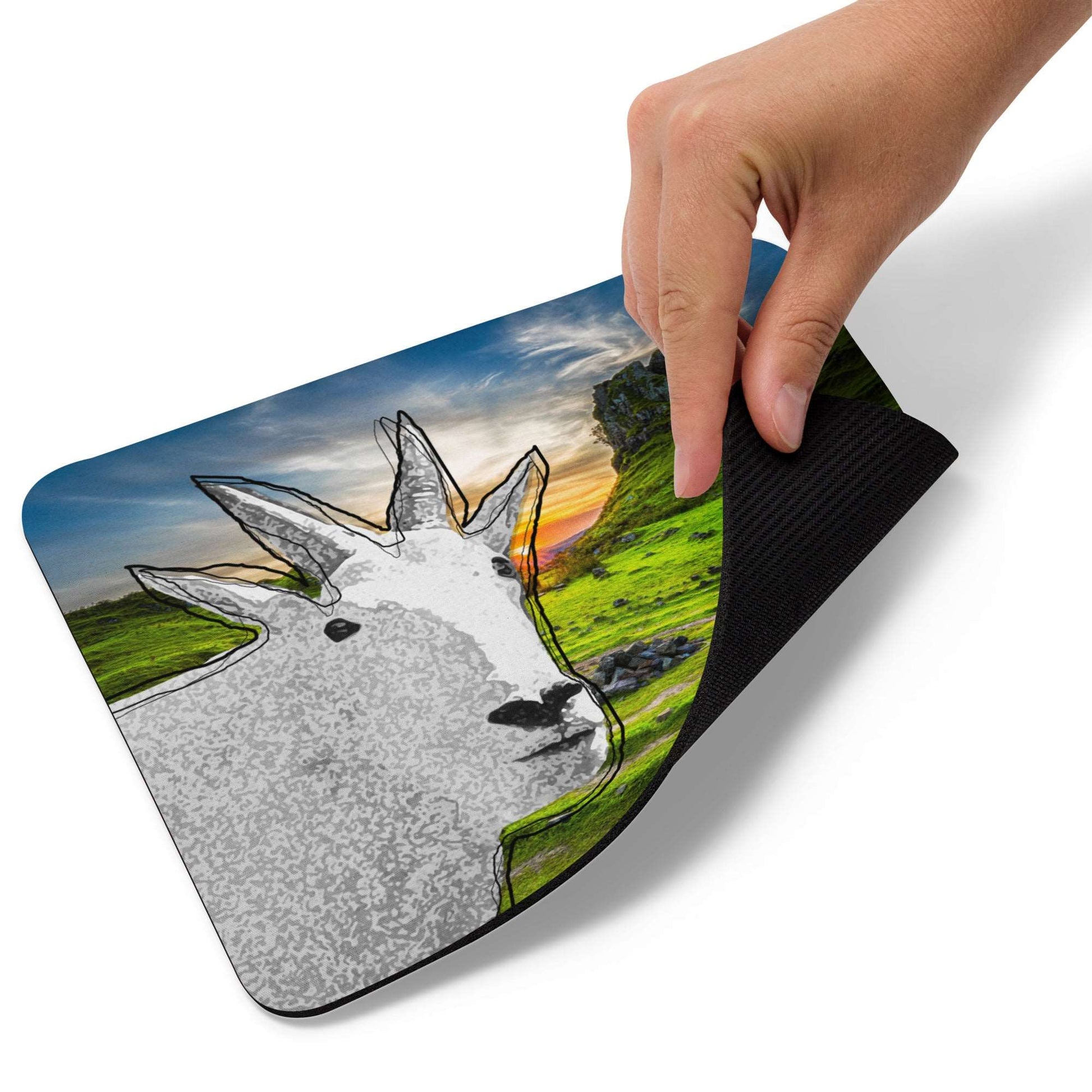 A high-quality mouse pad featuring a funny mountain goat design over a green mountain background.