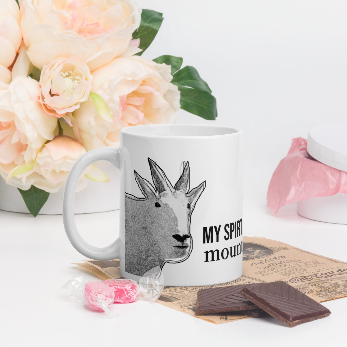 A white glossy mug that has a funny mountain goat design, the quote "My Spirit Animal is a Mountain Goat", and the logo North American Mountain Goat Appreciation Club.