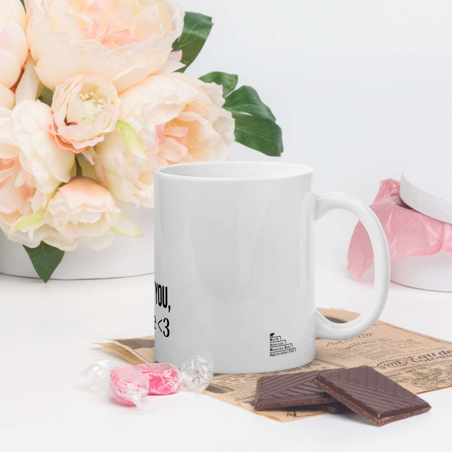 A white glossy mug that has a funny mountain goat design, the quote "I Goat You, Babe.", and the logo North American Mountain Goat Appreciation Club.