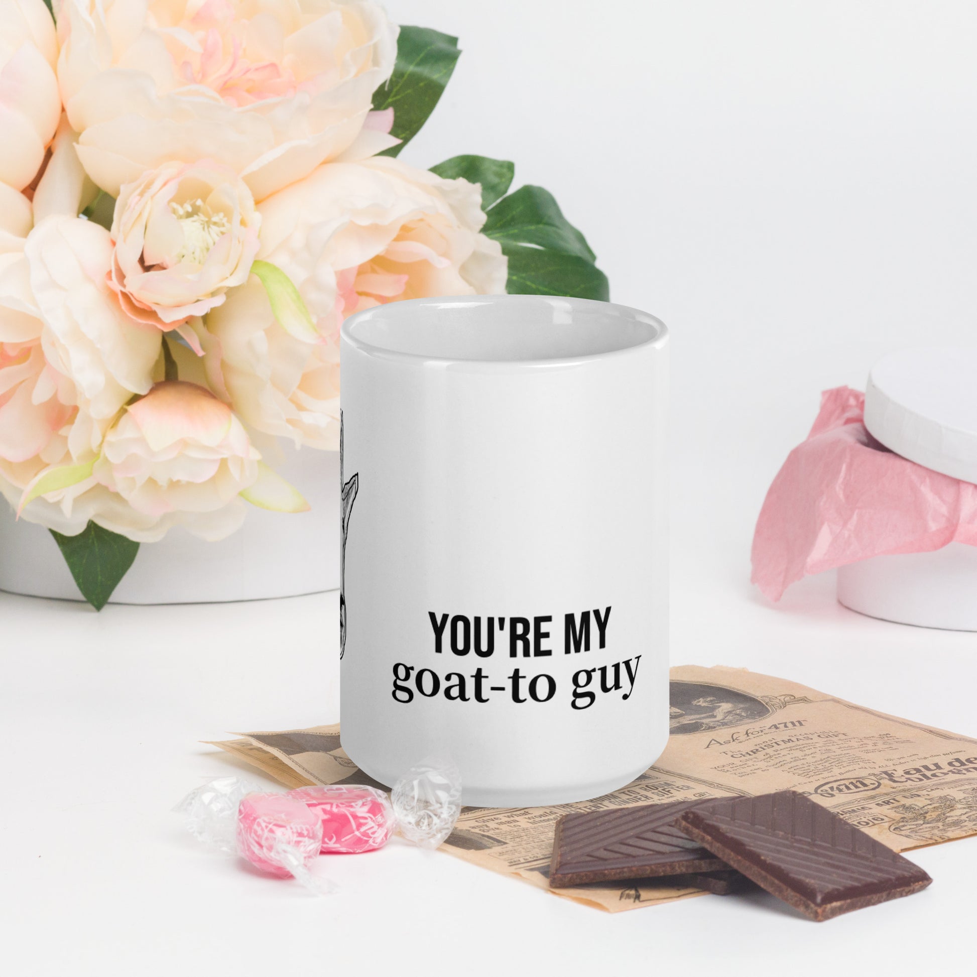 A white glossy mug that has a funny mountain goat design, the quote "You're My Goat-To Guy", and the logo North American Mountain Goat Appreciation Club.