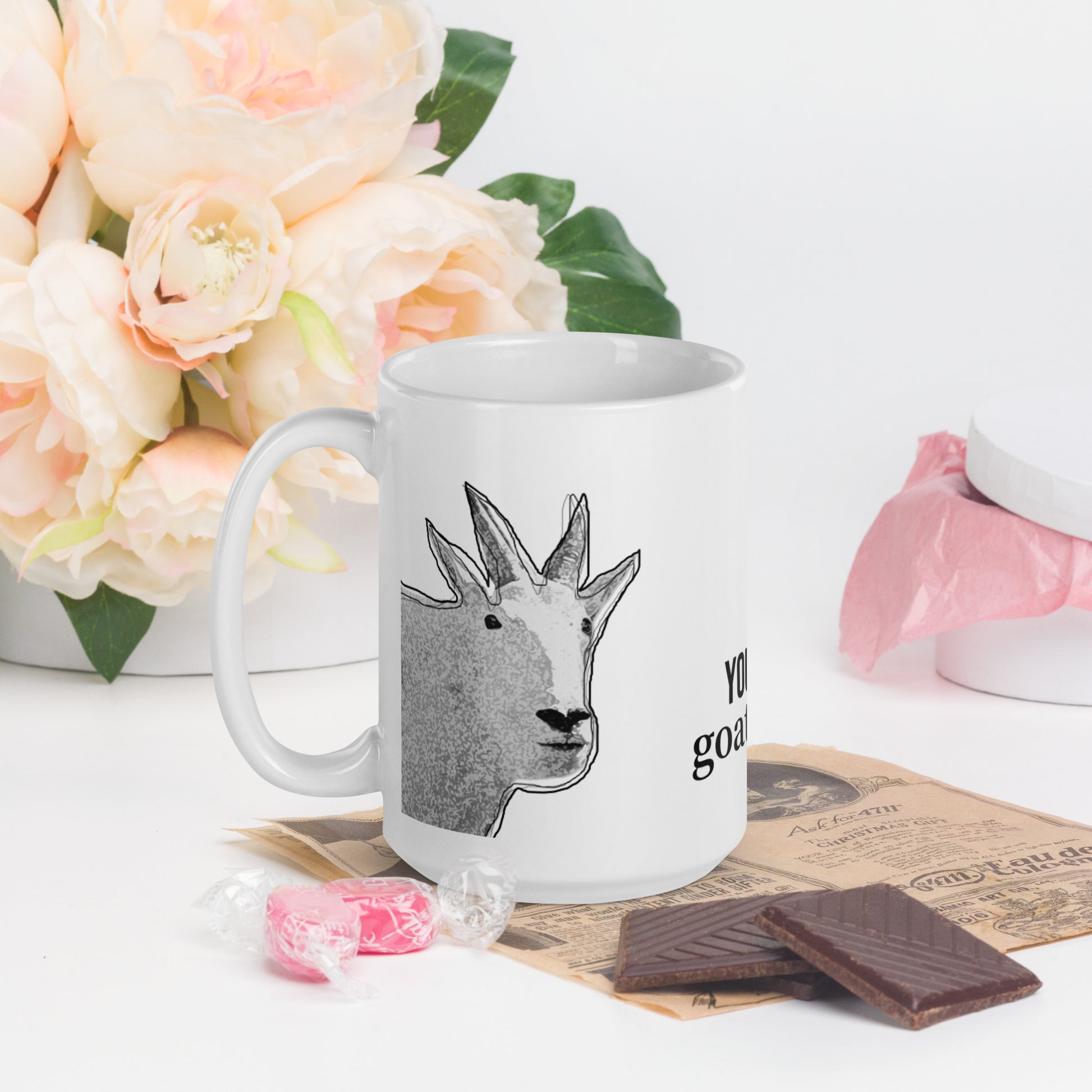 A white glossy mug that has a funny mountain goat design, the quote "You're My Goat-To Guy", and the logo North American Mountain Goat Appreciation Club.