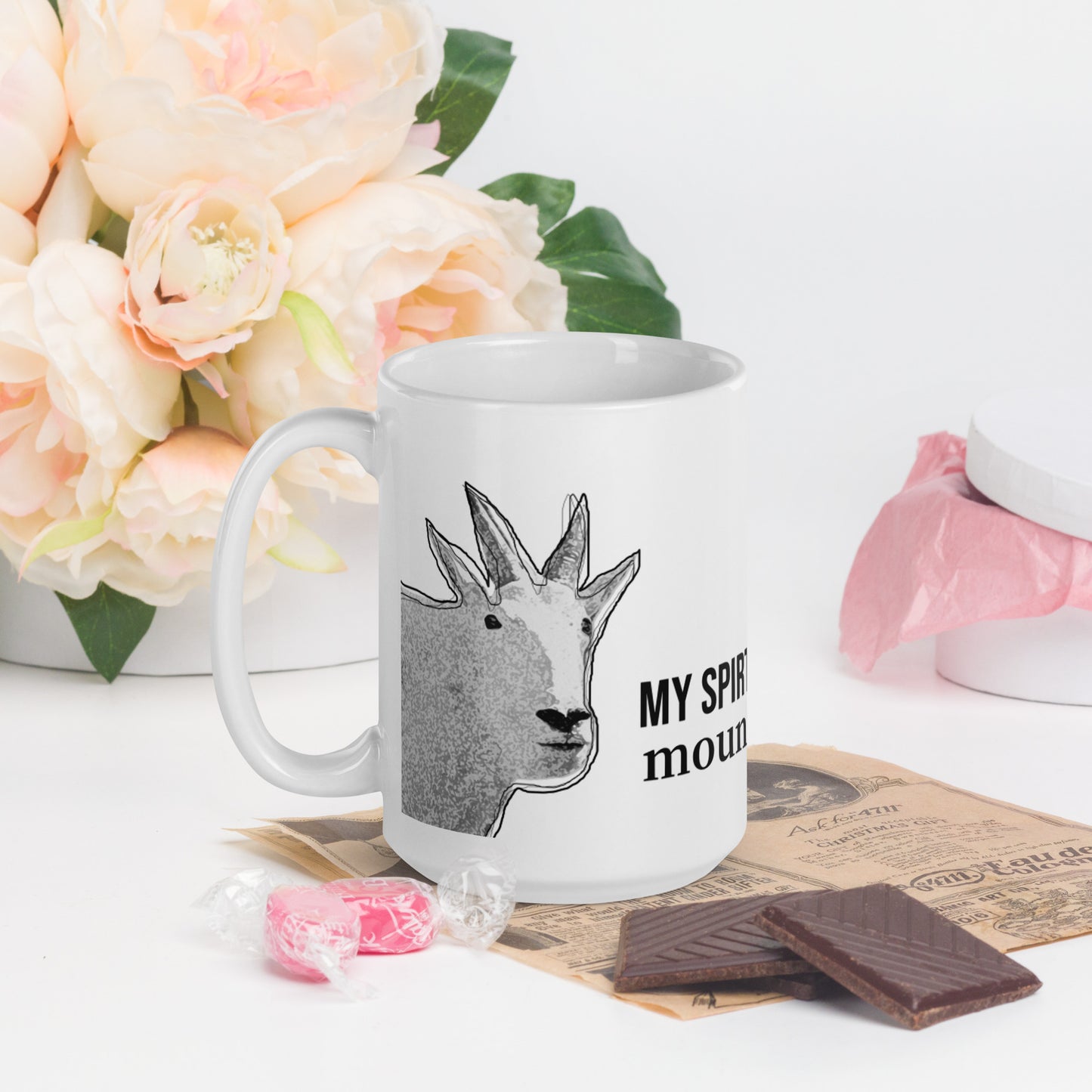 A white glossy mug that has a funny mountain goat design, the quote "My Spirit Animal is a Mountain Goat", and the logo North American Mountain Goat Appreciation Club.