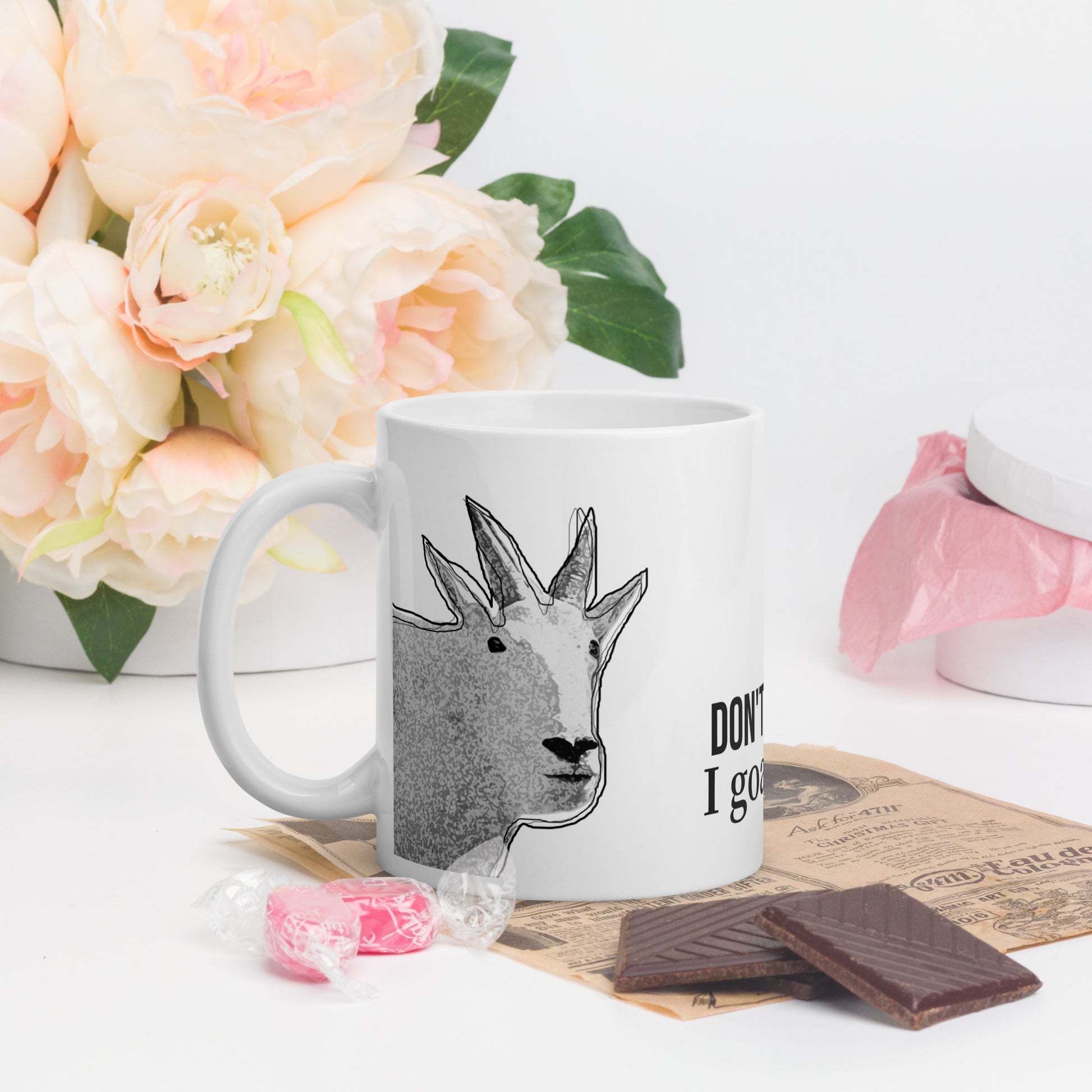 A white glossy mug that has a funny mountain goat design, the quote "Don't Worry. I Goat This.", and the logo North American Mountain Goat Appreciation Club.